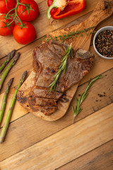 Steak with vegetables on a wooden background, restaurant and hotel business, menu, homemade recipes, culinary background, vertical photo, banner