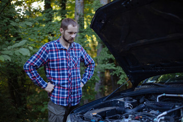 The guy looks at the car engine