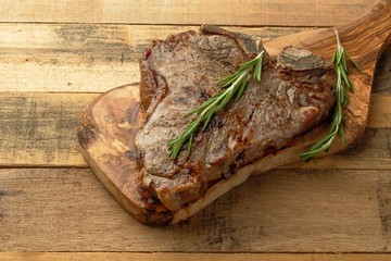 Marbled beef steak on rosemary board, on wooden background, restaurant menu, gastronomy, delicious food