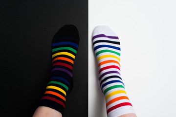 Legs with white and black striped new clean colorful textile socks. Fashion accessories for feet with negative background with copy space