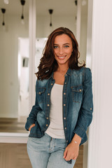 Vertical photo of europen woman with dark hair and tanned skin looking at camera