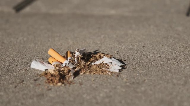 a woman tramples cigarettes on asphalt, stop smoking, quit smoking