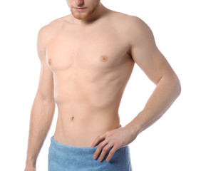 Fototapeta premium Young man with slim body in towel on white background, closeup