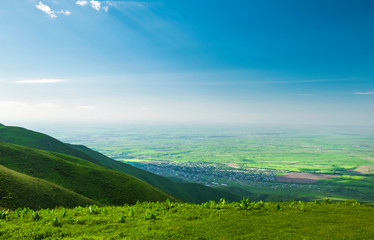 beautiful view from the green hill with a small town downhill