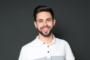 Portrait of handsome smiling man on grey background