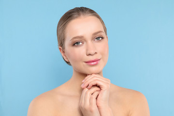 Portrait of young woman with beautiful face on blue background