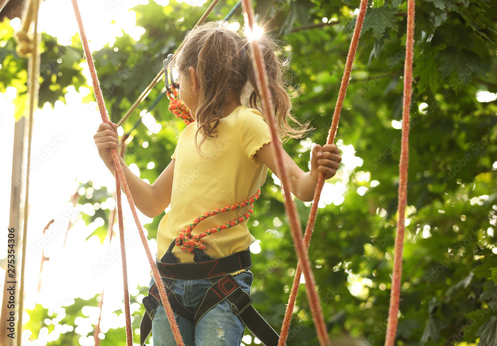 Sticker Little girl climbing in adventure park. Summer camp