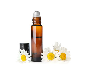 Bottle of herbal essential oil and chamomile flowers isolated on white