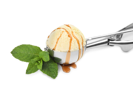 Delicious ice cream with caramel sauce in scoop and mint on white background
