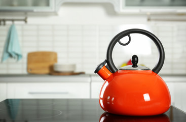 Modern kettle with whistle on stove in kitchen, space for text