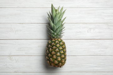 Fresh whole pineapple on white wooden background, top view