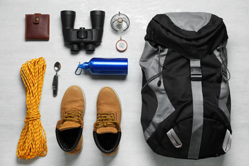 Flat lay composition with different camping equipment on light background