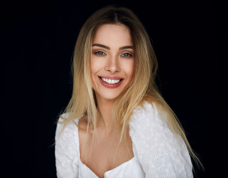 Portrait Of Smiling Blonde Woman Looking At Camera And Isolated On Black Background