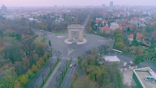 Aerial view of triumphal arch in Bucharest. Morning light. Aerial footage of an arch and boulevards surrounding it on a sunset in Bucharest. Arc de triumph.  Romania Bucharest. Sunrise. Sunset
