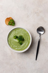 Broth with broccoli in bowl with spoon and crouton