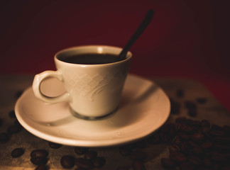 Taza rodeada por varios granos de café