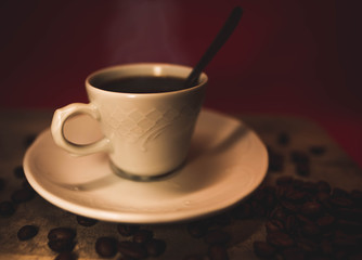 Taza rodeada por varios granos de café