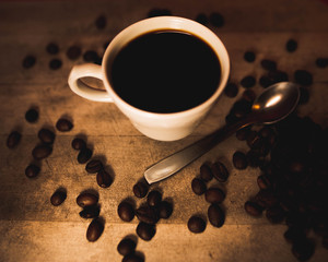 Taza rodeada por varios granos de café