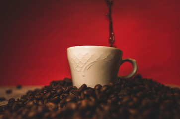 Taza rodeada sobre una montaña de granos de café