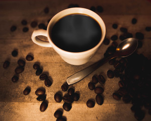 Taza rodeada por varios granos de café