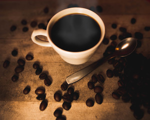 Taza rodeada por varios granos de café