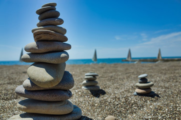 Stones pyramid on pebble beach symbolizing stability, zen, harmony, balance. Shallow depth of field. Black Sea.