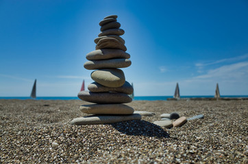Stones pyramid on pebble beach symbolizing stability, zen, harmony, balance. Shallow depth of field.