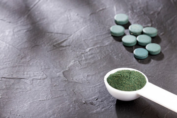 spirulina powder and spirulina pills - healthy superfood diet and detox nutrition concept - Text space