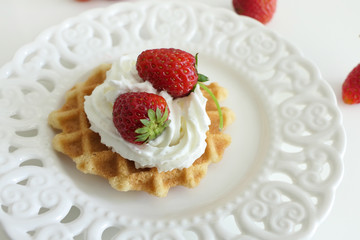 Waffle with Cream and Strawberries in a White Plate isolated on a White Background
