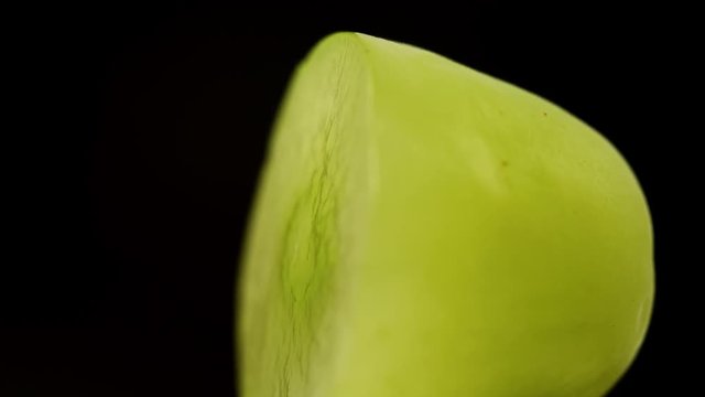 Half of a green grape on black background