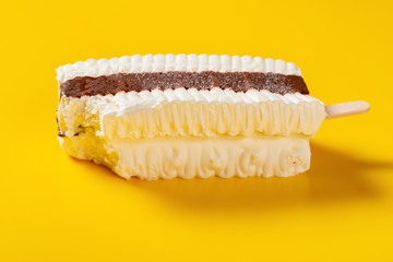 side view fresh chocolate and milkshake flavor popsicle with a bite on a yellow background