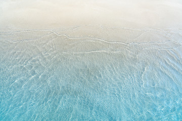 Soft wave of blue ocean on sandy beach. Summer background.