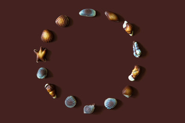 Assorted Chocolate pralines with sea concept on brown background.