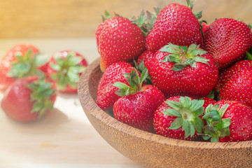 Fresh beautiful strawberries in wooden bowl. Strawberry fruits on wooden table .