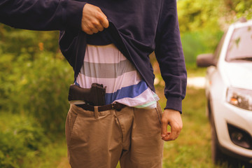 burglar in mask holding and reloading the pistol outdoor