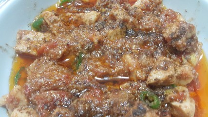 A close up view of stewed chicken meat cubes with spices on it