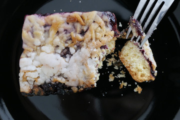 Eating Delicious Homemade Cake from a Black Plate