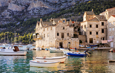 Sea village life in the town of Vis in Croatia with boats in the harbor. 