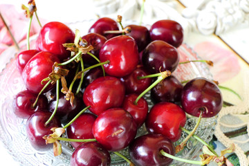 Fresh Dark Red Cherries in a Transparent Plate on a Colorful Background