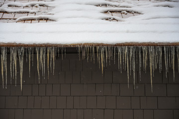 Icicles Cling to Edge of Snowy Roof