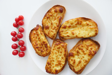Roasted Cheese Toasts and Cherry Tmatoes in a White Plate