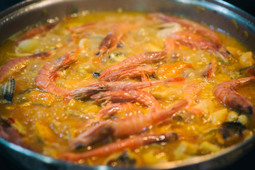 Recipe to prepare a paella: adding prawns