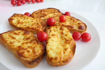 Roasted Cheese Toasts and Cherry Tmatoes in a White Plate