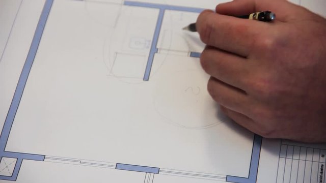 Architect looking over floor plans and taking notes.
