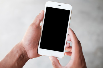Cropped shot view of man hands holding smart phone with blank copy space screen for your text message or information content, female reading text message on cell telephone during in urban setting. 