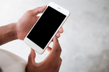 Cropped shot view of man hands holding smart phone with blank copy space screen for your text message or information content, female reading text message on cell telephone during in urban setting. 