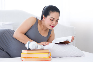 Pregnant woman reading a book for relaxation.