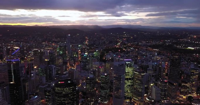 Fast moving aerial timelapse hyperlapse of a modern city with tall buildings by the river at sunset. Brisbane, Australia.