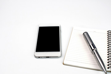 smartphone,memo pad and pencil on white desk