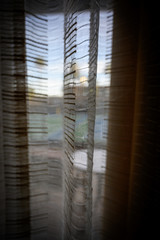 Looking through stripped window shades at a hotel basketball court